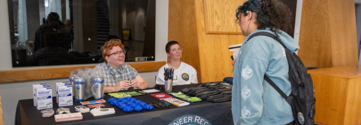 A student and staff member tabling and talking to a student.